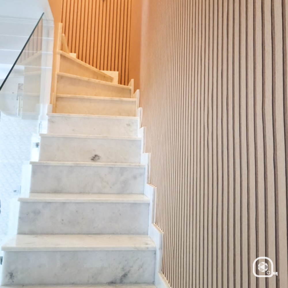 Papel de parede listrado em parede de escada com degraus de mármore.
